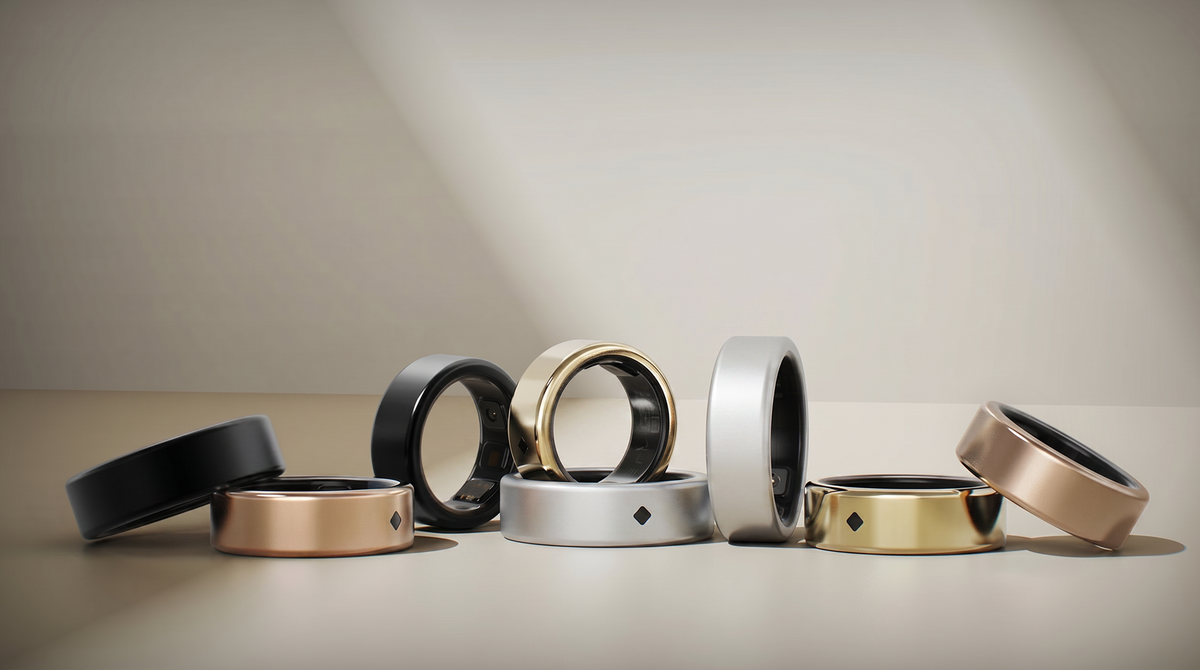 AIVELA rings in refined metallic finishes, arranged in warm studio light